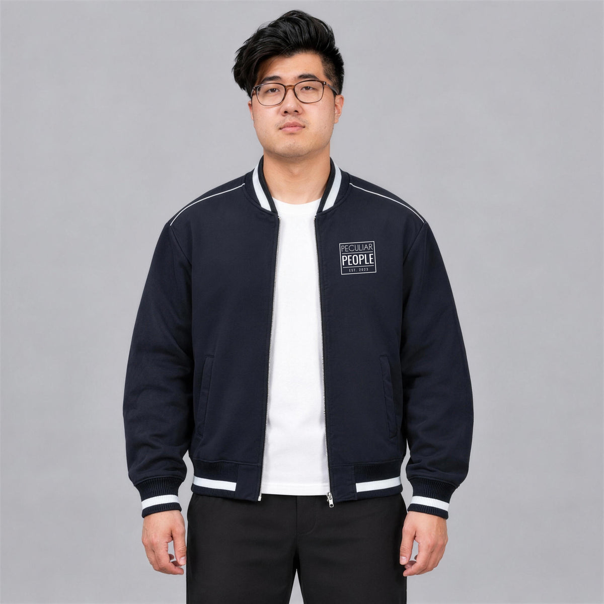 Temple Seal bomber jacket chest logo on model, unzipped over a white tee - Navy Blue