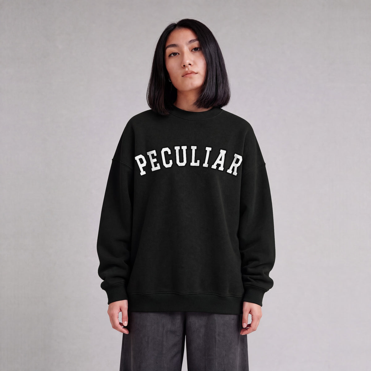 "Peculiar" collegiate sweatshirt front print on model - Black