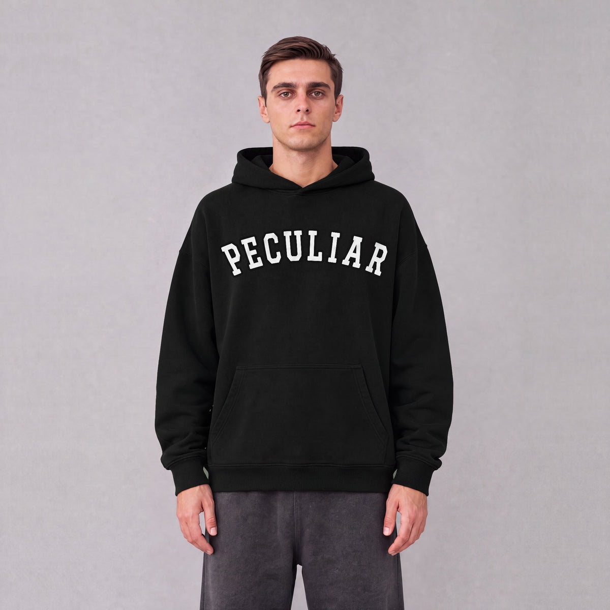 "Peculiar" collegiate hoodie front print on model - Black