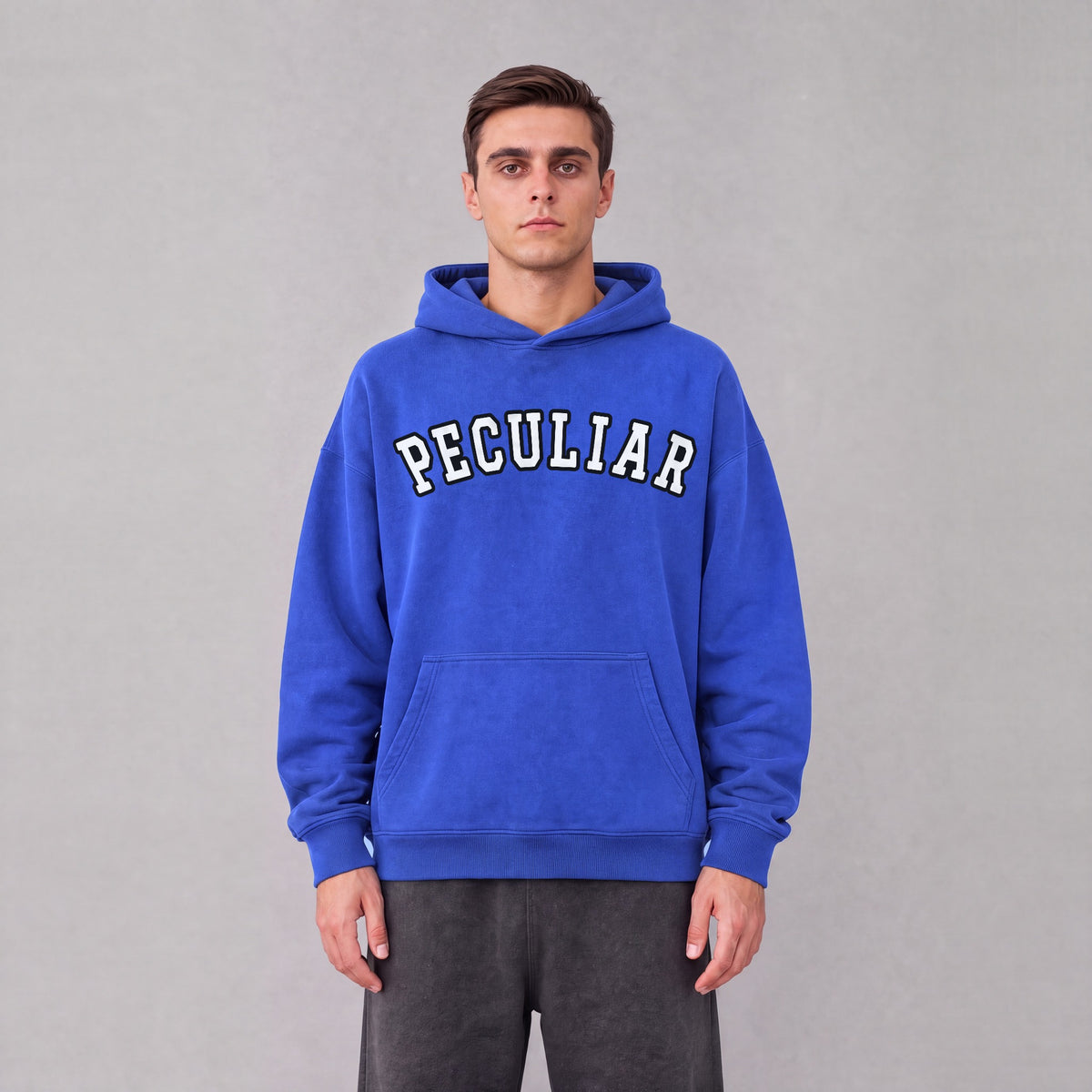 "Peculiar" collegiate hoodie front print on model - Royal Blue